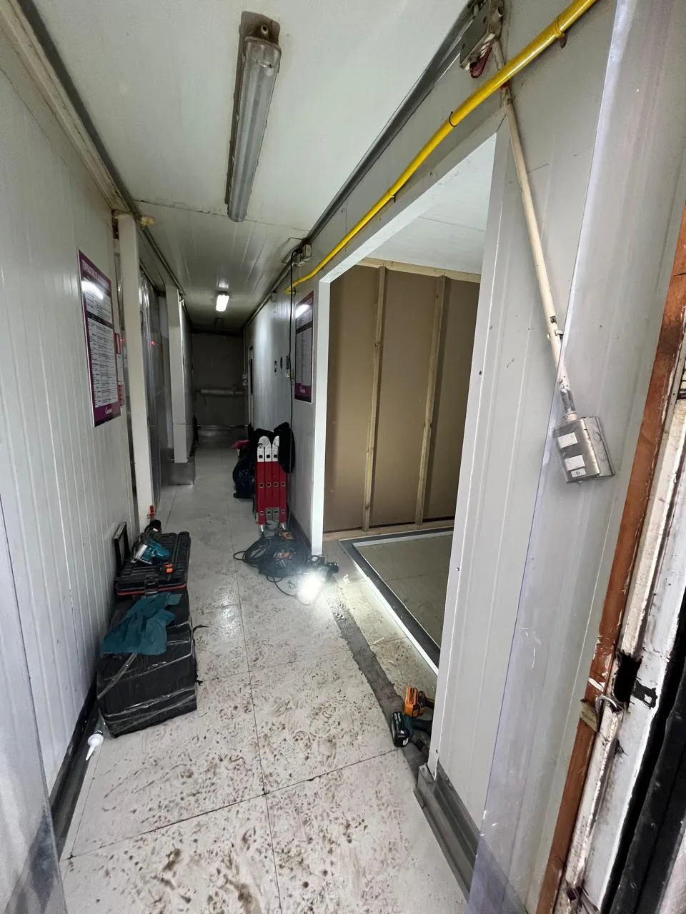 Pasillo del centro de distribución con las cámaras en obra y carteles de parámetros de temperatura